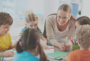 Teacher is happily listening to her students while doing their activities.