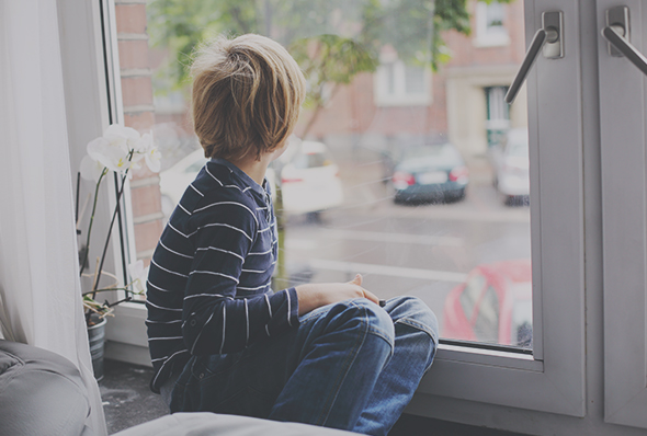 A boy looking at a window.