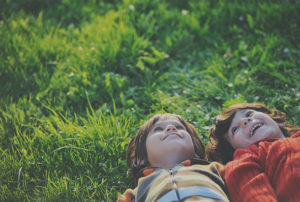 Siblings lying in the field