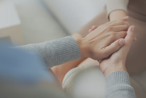 A psychiatrist in Brisbane holding hands with her patient with depression and anxiety problems.